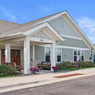 A suburban residential house with a front porch and landscaped surroundings.
