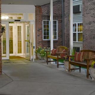 A building entrance with benches outside, illuminated at night.
