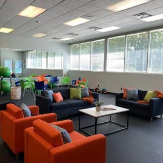 A vibrant lounge space featuring comfortable seating and large windows, perfect for relaxation or informal meetings.