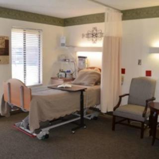 A hospital room with a bed, medical equipment, and seating.