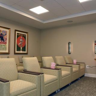 A well-arranged waiting room with comfortable chairs and framed artwork on the wall.