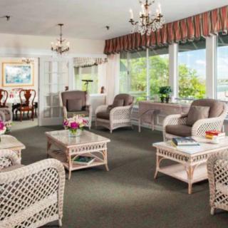 A cozy and elegant living room with wicker furniture and large windows.