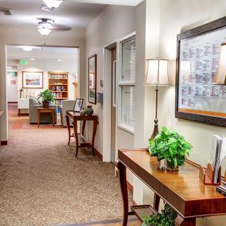 A well-decorated hallway with furniture and plants, leading to a cozy living area.