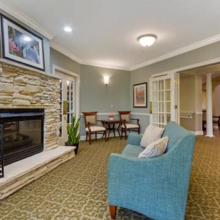 A cozy living room featuring a stone fireplace, comfortable armchair, and elegant decor.