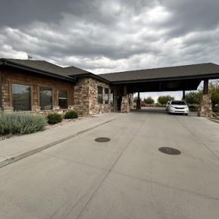 A welcoming entrance to a modern building under a partly cloudy sky.