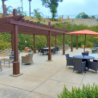 Outdoor patio area with pergolas and furniture.