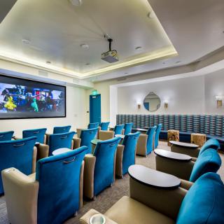 A modern home theater with comfortable seating and a large screen.