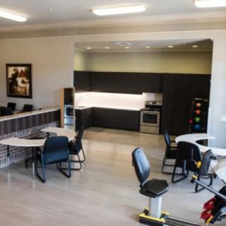 A modern office space featuring a kitchenette and seating area.