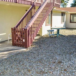 An outdoor area with a gravel ground, featuring a staircase leading to an upper level of a house.