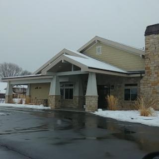 A modern building entrance covered in snow, showcasing a blend of stone and contemporary design.