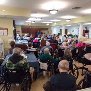 A lively gathering of seniors at a nursing home, participating in a community event.
