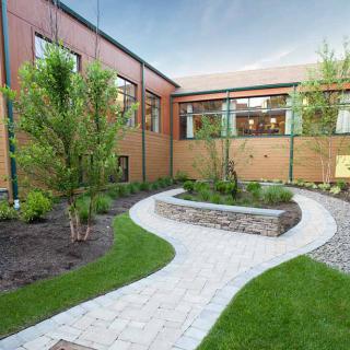 A landscaped courtyard with a winding pathway and surrounding greenery.