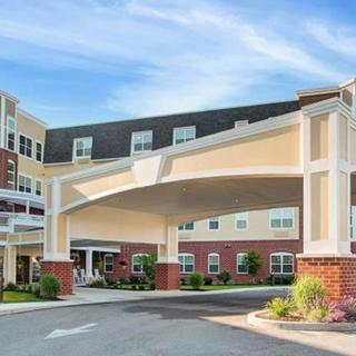 A modern hotel entrance with a covered driveway and landscaped surroundings.