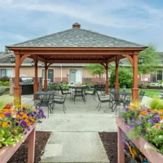 A charming gazebo with outdoor seating surrounded by vibrant flowerbeds.