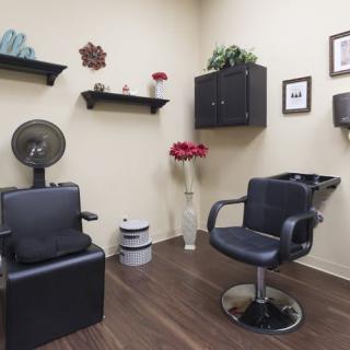 A neatly organized hair salon with styling chairs and wall decorations.