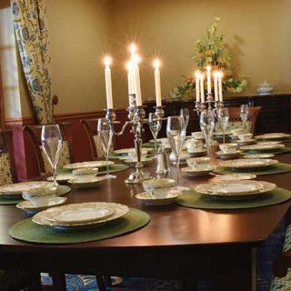 A beautifully set dining table with candles and elegant place settings.