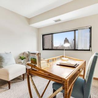 A bright and serene office space featuring a stylish desk and comfortable seating, perfect for productivity.