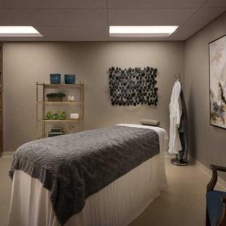 A serene spa massage room with a comfortable bed and soothing decor.