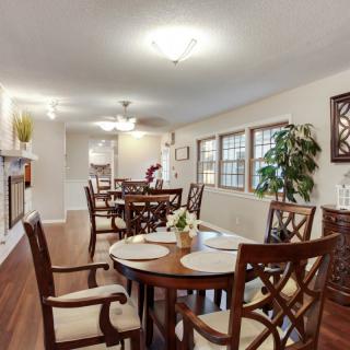 A spacious dining room with elegant wooden furniture and ample natural light.