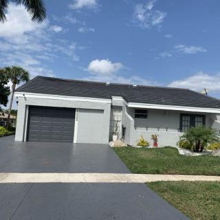 A single-story house with a garage and a well-maintained lawn on a cloudy day.