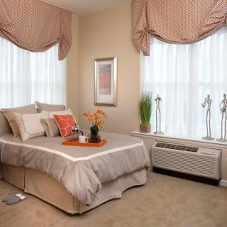 A cozy bedroom with elegant drapes and a well-made bed.