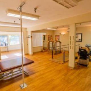 A spacious rehabilitation therapy room equipped with various exercise equipment.