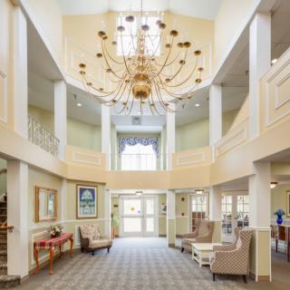 A spacious lobby area with a large chandelier and comfortable seating.