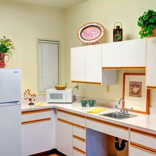A bright kitchen interior with white cabinets, appliances, and decorative elements.