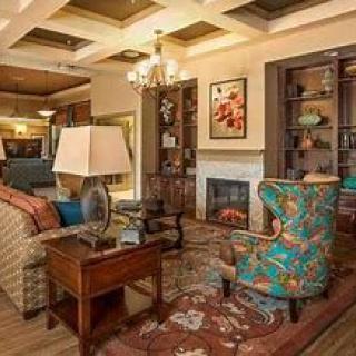 A cozy living room with a colorful armchair, fireplace, and elegant decor.