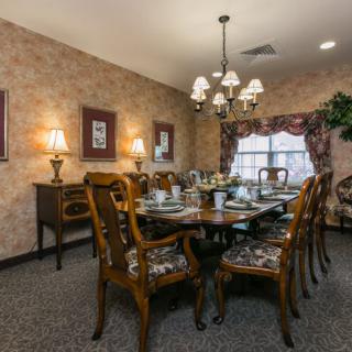 A traditionally decorated dining room with a large table and chandelier.