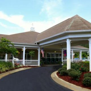 A beautifully landscaped entrance to a building with a covered driveway.