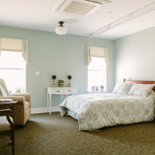 A serene and inviting bedroom featuring soft colors and comfortable furnishings.