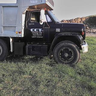 A black commercial truck parked on green grass in an outdoor setting.