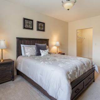 A cozy and well-decorated bedroom with a large bed and two bedside lamps.