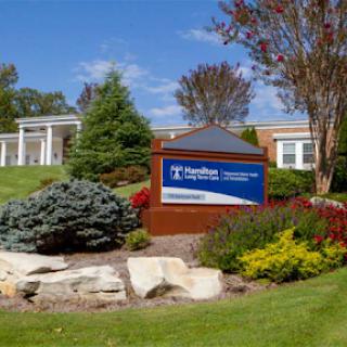 A well-maintained building with beautiful landscaping and a clear sign.