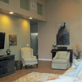 A cozy living room with chairs, artwork, and a television.