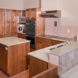 Modern kitchen with wooden cabinets and integrated appliances.
