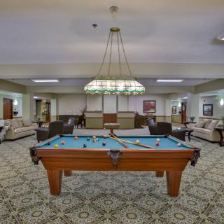 A spacious game room with a pool table and comfortable seating area.