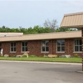 A single-story brick commercial building with a metal roof and multiple windows.