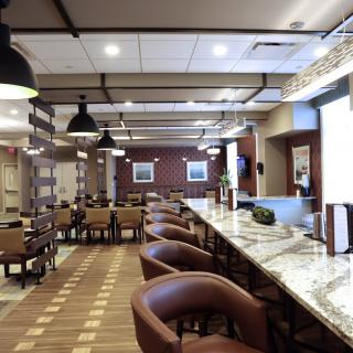 A modern restaurant interior with a bar and ample seating.
