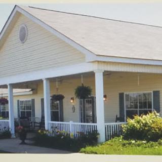 A charming residential home with a welcoming porch and well-kept garden.