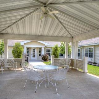 A cozy outdoor gazebo with a table and chairs, perfect for relaxation in the garden.