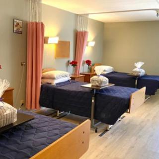 A hospital room with neatly arranged beds and privacy curtains.