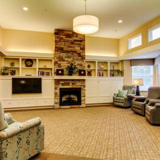 A cozy living room with a fireplace, comfortable seating, and warm lighting.