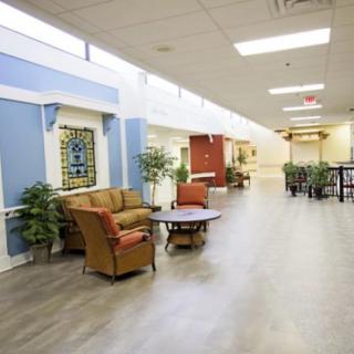 A spacious corridor with a comfortable seating area and decorative plants.