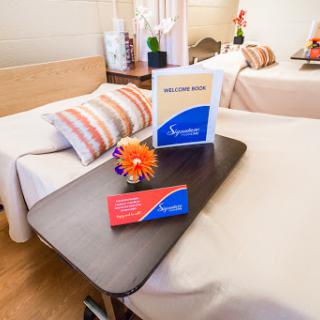 A well-appointed patient room in a medical facility, featuring comfortable beds and decorative elements.
