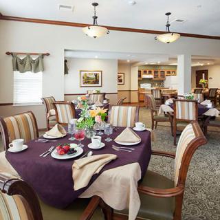 A well-appointed dining room with a neatly set table, featuring elegant decor and comfortable seating.