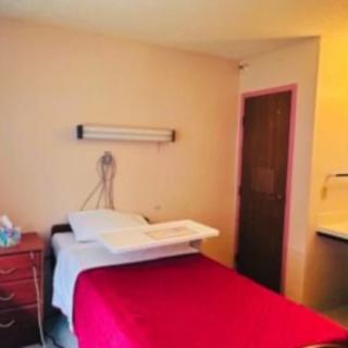 A simple hospital room with a bed and minimal furnishings.
