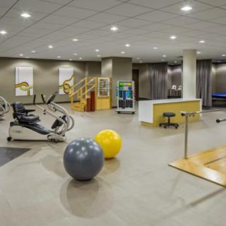 A modern gym interior featuring exercise equipment and therapy balls.