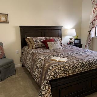 A cozy bedroom with a neatly made bed and warm lighting.